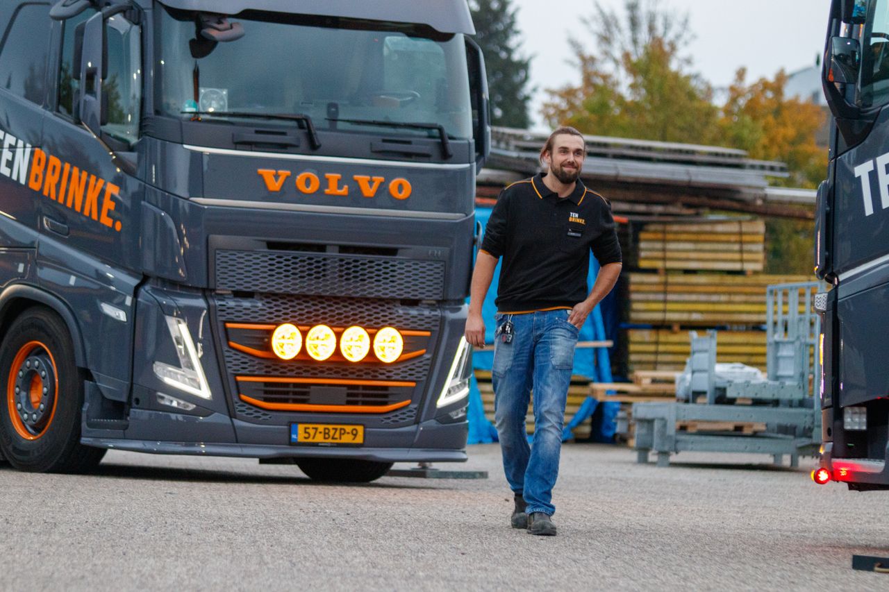 The Art of Drawing Readers In: Your attractive post title goes here Truck driver walking near a Volvo truck in an industrial area during the day, showcasing logistics and transportation.